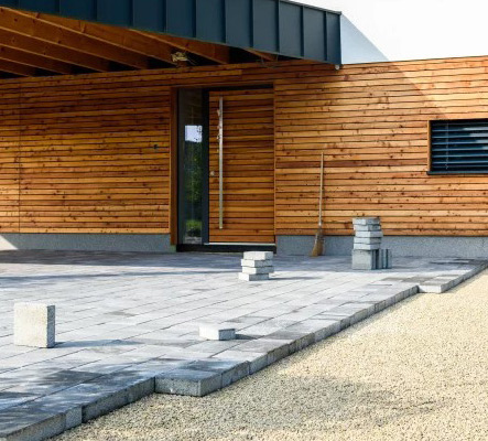 Sauber verlegte Pflasterfläche mit Betonsteinen und präziser Randgestaltung im Eingangsbereich.