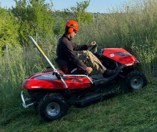 Professionelle Rasenpflege mit einem Aufsitzrasenmäher auf einer großzügigen Grünfläche.