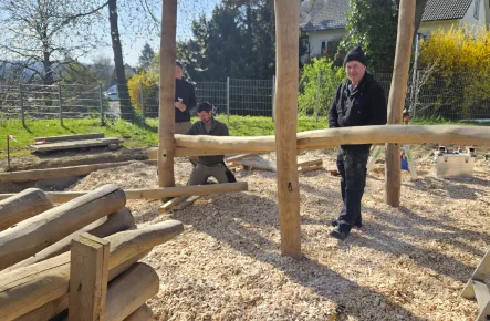 Mitarbeiter beim Aufbau einer Spielanlage aus Holz.
